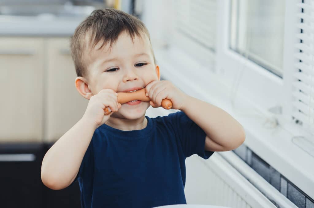 Kind beißt in Wurst